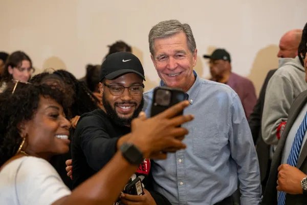 photo of Roy Cooper posing for a picture with union members in Charlottee